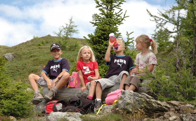 Children enjoying a family hiking adventure in the Dolomites mountains during summer.